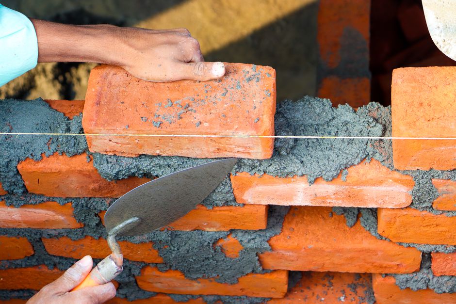 Mason laying a brick wall